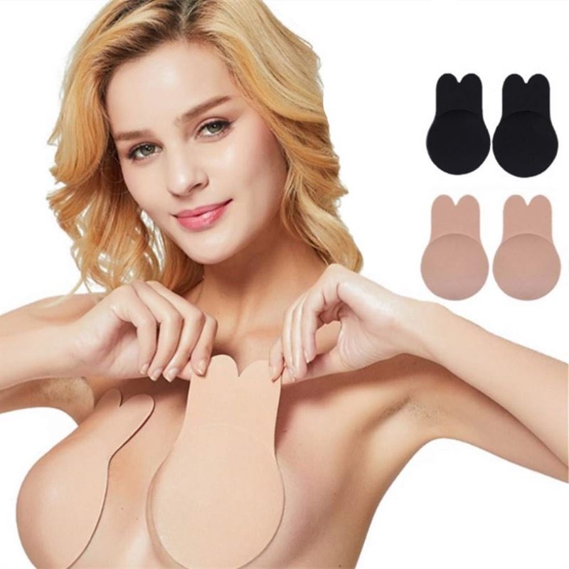 A woman showcases Shapelux Lifting Pads for Invisible Breast Lift—strapless, strong adhesive tape in beige—plus extra pairs shown beside her, designed to lift and support breasts seamlessly without straps.