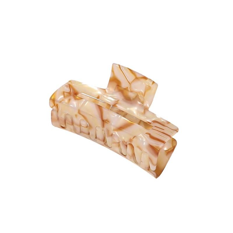 The SOHO Aria Hair Claw - Champagne by SOHO features a rectangular, curved-edge design in beige and light brown marbled acetate, creating a chic hair accessory displayed on a white background.