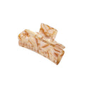 The SOHO Aria Hair Claw - Champagne by SOHO features a rectangular, curved-edge design in beige and light brown marbled acetate, creating a chic hair accessory displayed on a white background.