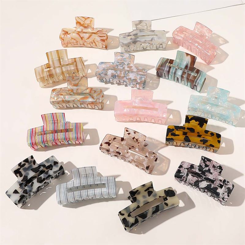 The SOHO Aria Hair Claw in Champagne, by SOHO, is a stylish large rectangular accessory featuring chic color and pattern options—like tortoiseshell, stripes, marbled, and pastels—perfectly arranged on a light background.