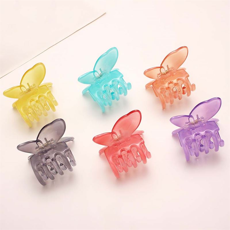Six SOHO Ella Hair Claw - Arctic clips in yellow, blue, orange, purple, grey, and pink are arranged in two rows on a light background. Each translucent butterfly clip from SOHO features a spring for adorable hairstyles.