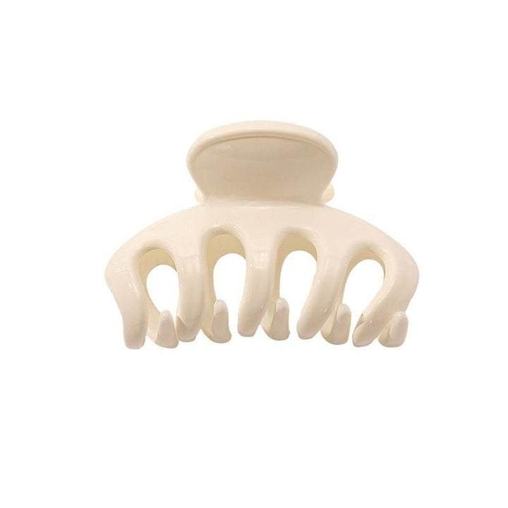 The SOHO Esta Hair Claw - White by SOHO is a small, cream-colored plastic clip with five rounded prongs for extra grip, ideal for secure hairstyling. Shown against a plain white background.