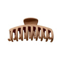 Die SOHO Kana Hair Claw – Beige verfügt über breite, gebogene Zinken für einen festen Halt bei allen Haartypen und ist vor einem weißen Hintergrund abgebildet.