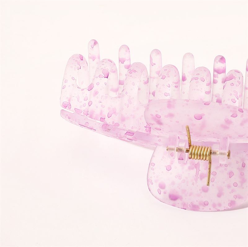 The SOHO Kana Splash Hair Claw in blue features a translucent, speckled design with a gold spring for a strong grip suitable for all hair types. Displayed on a white background.