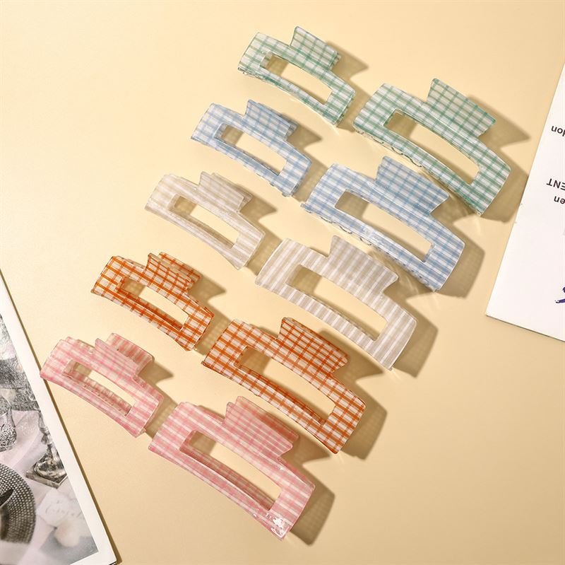 The SOHO Line Hair Claw - Green by SOHO adds a vibrant touch to any style. This secure-hold hair accessory, featuring a trendy checkered pattern, keeps your hair in place while offering standout style.