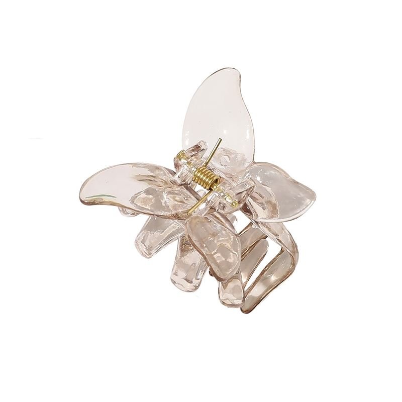 The SOHO Naja Hair Claw - Espresso by SOHO is a transparent brown hair accessory with a metallic spring, combining style and practicality for any occasion.