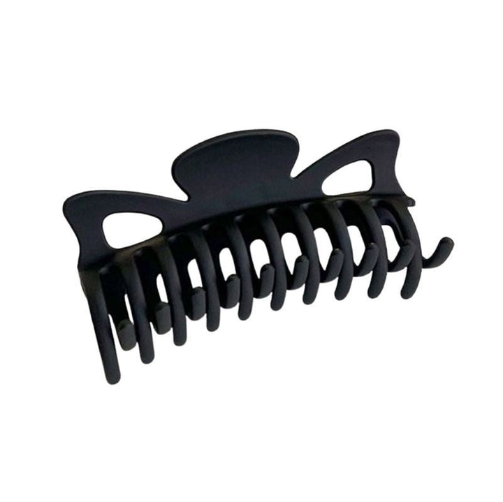 The SOHO Zara Hair Claw - Black by SOHO is a large black plastic hair clip with interlocking curved prongs and decorative cut-out shapes on top.