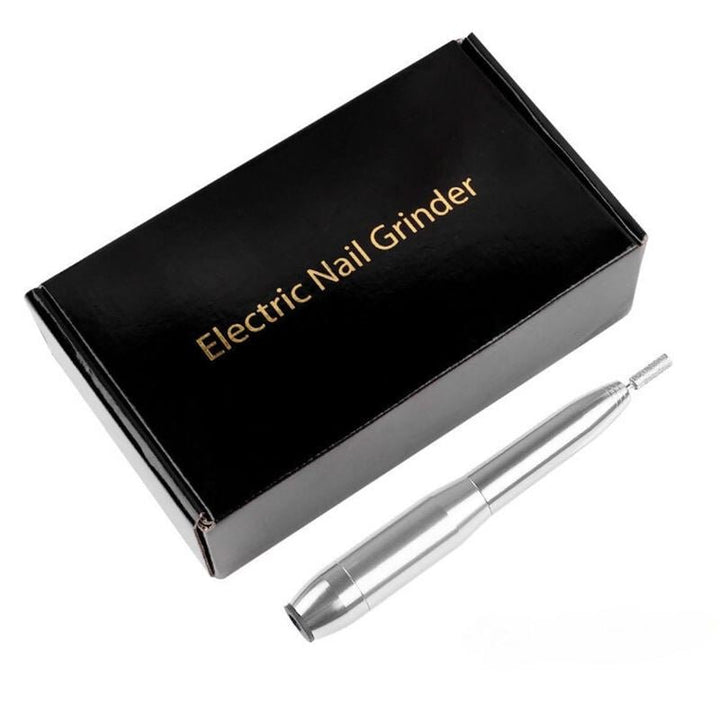 The UNIQ Compact Electric Nail File Kit, a silver portable e-file for manicure and pedicure, is displayed beside a black box with gold “Electric Nail Grinder” text on a white background.