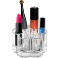 Der UNIQ Flower Makeup Acrylic Organiser – U301 von UNIQ verfügt über mehrere Fächer für Artikel wie rosa Lippenstift, einen Applikatorpinsel, orangefarbenen Lipgloss, Nagellack und eine blaue Nagellackflasche. Dieser stilvolle Organizer hebt sich auf weißem Hintergrund besonders hervor.