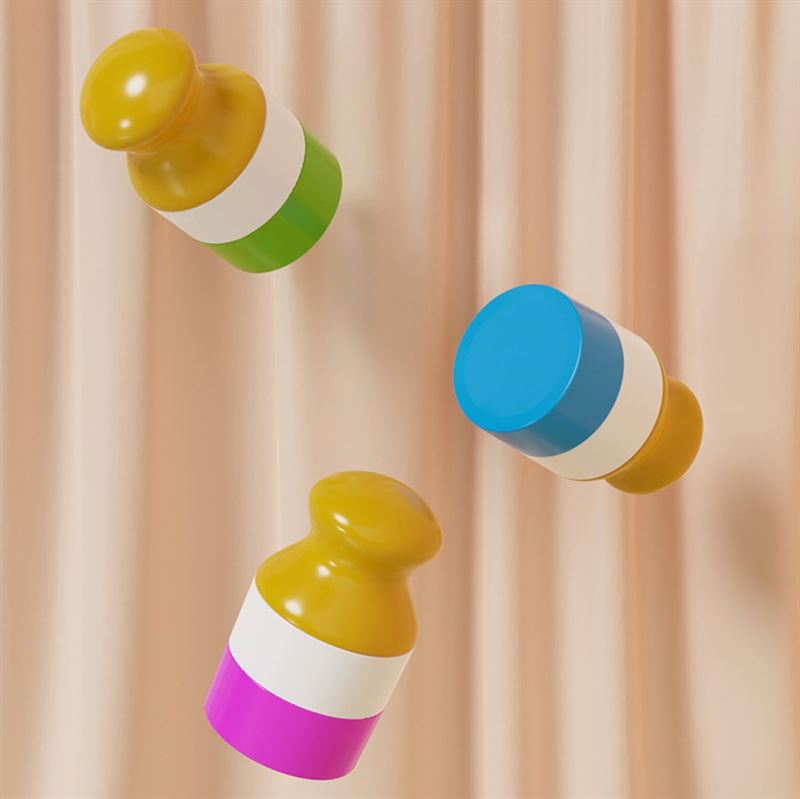 Three colorful UNIQ Portable Refillable Sponge Roller Applicators (100ml) for mess-free lotion or sunscreen, with rounded yellow tops and white bands, float in front of beige pleated fabric. Bases are green, blue, and pink.